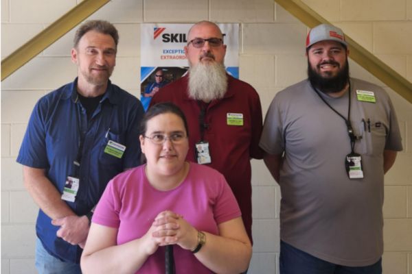 Cassandra Leaman standing with her new coworkers, smiling at the camera.