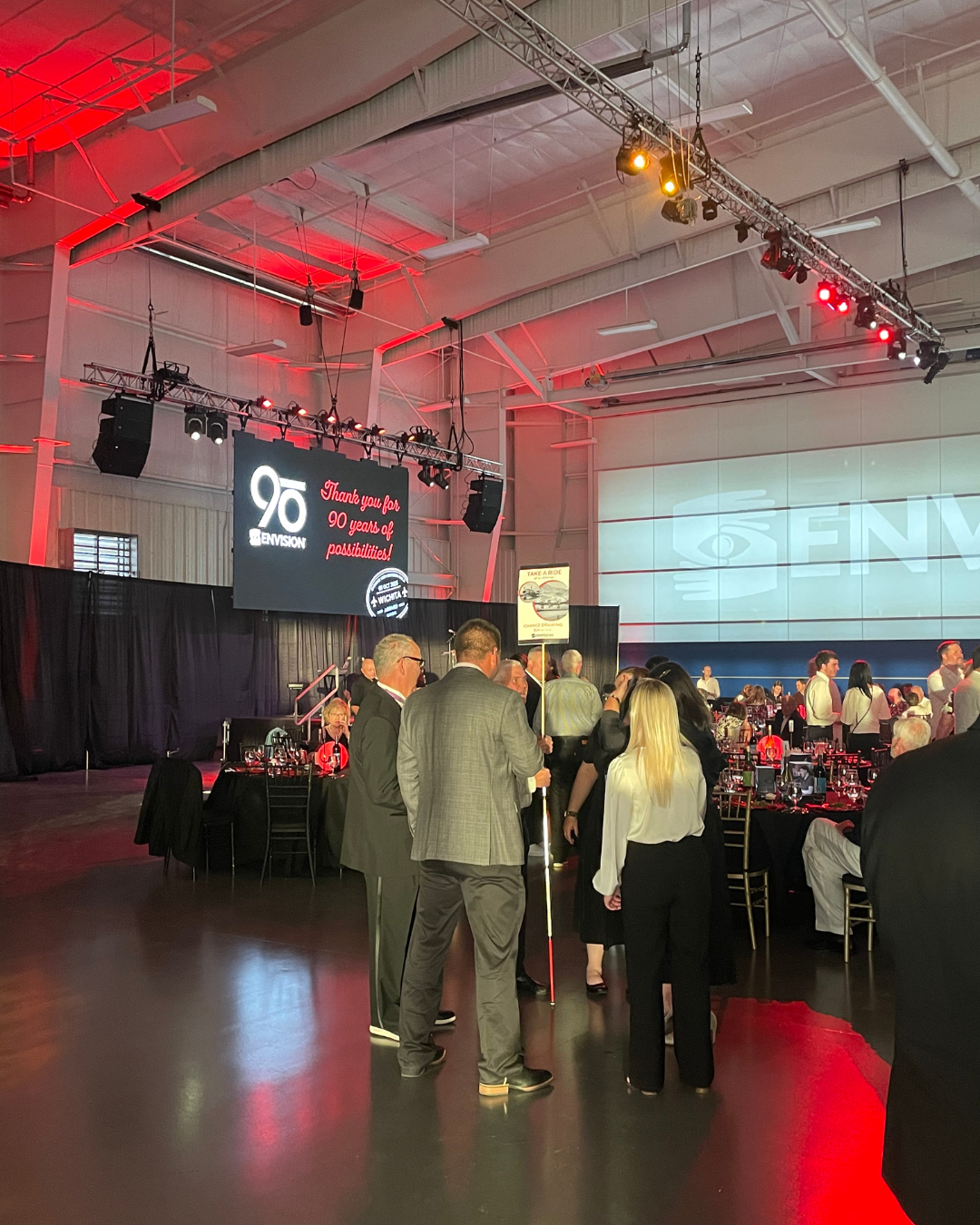 People standing in a room with a sign behind them that says "90 years of service."